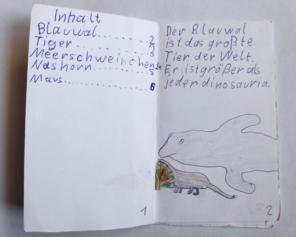 Minibuch von Kind gemacht: Titel: "Viele Tiere". Die erste Seite zeigt, dass der Blauwal größer als Dinosaurier sind.